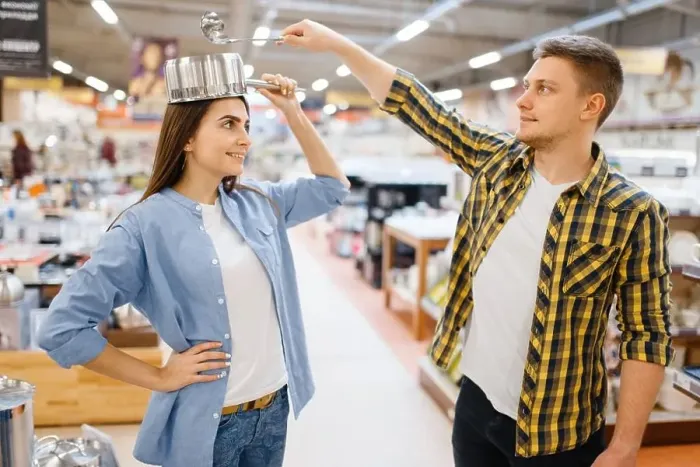 Framed Print : Young couple jokes with ladle and pan in houseware store Framed Print : Young couple jokes with ladle and pan in houseware store