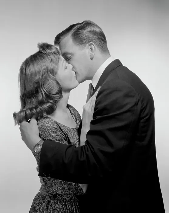 Framed Print : Young couple kissing, studio shot Framed Print : Young couple kissing, studio shot