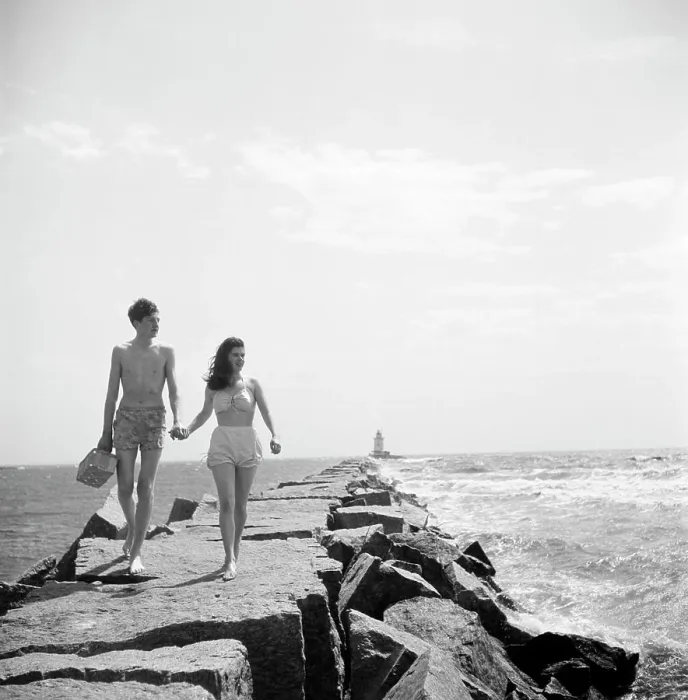 Framed Print : Young couple walking along groyne Framed Print : Young couple walking along groyne