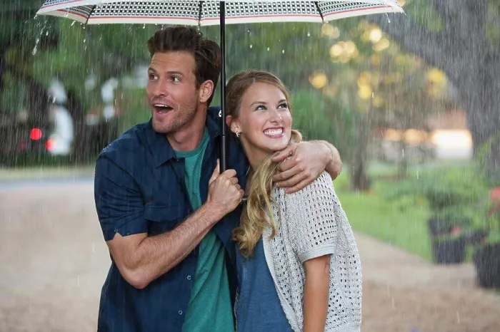 Framed Print : Young couple walking through park with umbrella in the rain, both looking out at the falling rain