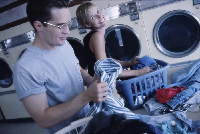 Framed Print : Young couple working in a laundromat