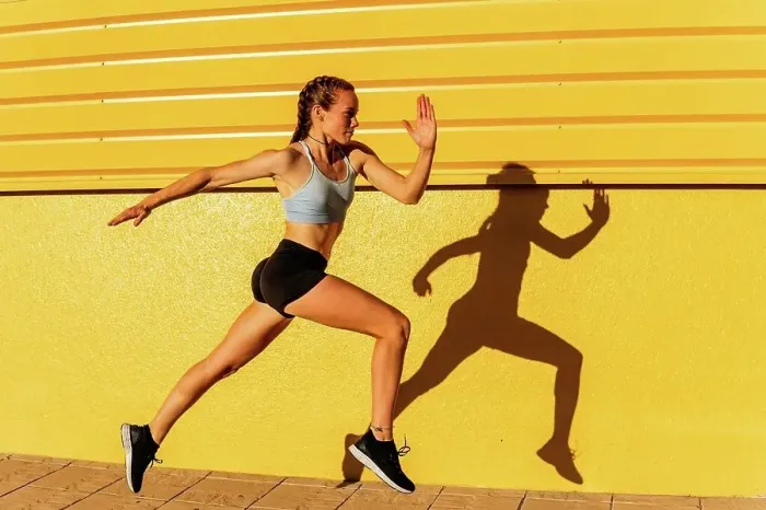 Framed Print : Young female athlete running by yellow wall Framed Print : Young female athlete running by yellow wall