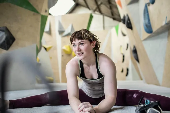 Framed Print : Young female rock climber stretching in climbing gym
