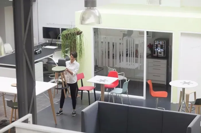 Framed Print : Young female sales manager inspecting office stool in office furniture store