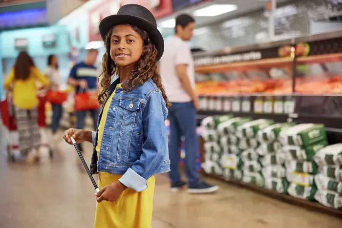 Framed Print : Young girl with magicians top hat and wand standing in isle of busy grocery store, customers in line at the meat market in the background Framed Print : Young girl with magicians top hat and wand standing in isle of busy grocery store, customers in line at the meat market in the background