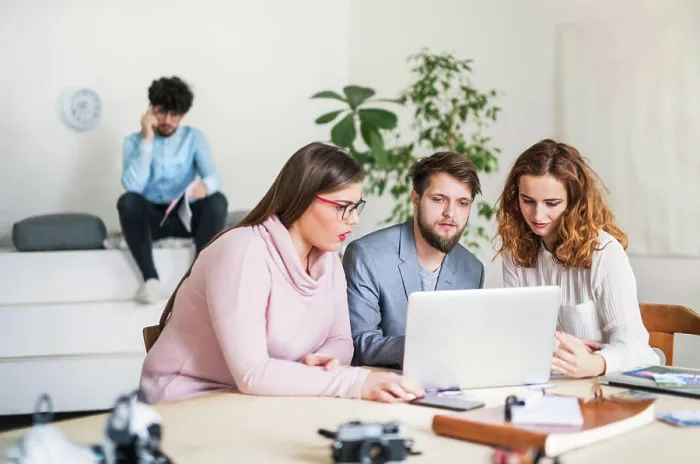 Framed Print : Young group of colleagues working on a new project together in a startup company office Framed Print : Young group of colleagues working on a new project together in a startup company office