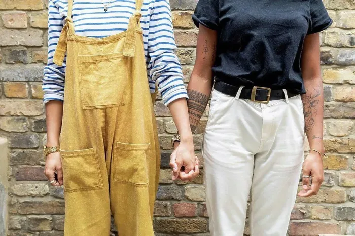 Framed Print : Young lesbian couple holding hands while standing against brick wall Framed Print : Young lesbian couple holding hands while standing against brick wall