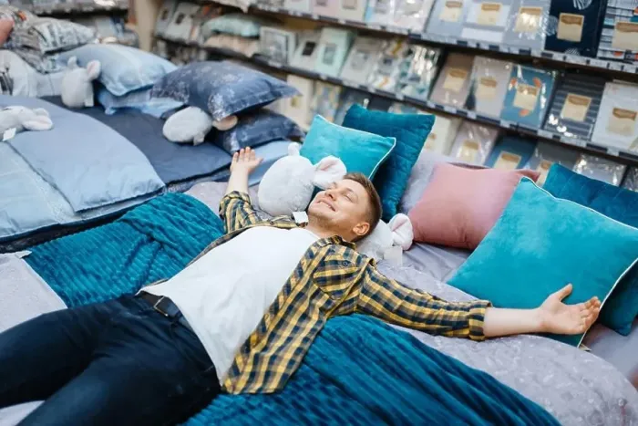 Framed Print : Young man lying on the bed in bedding store Framed Print : Young man lying on the bed in bedding store