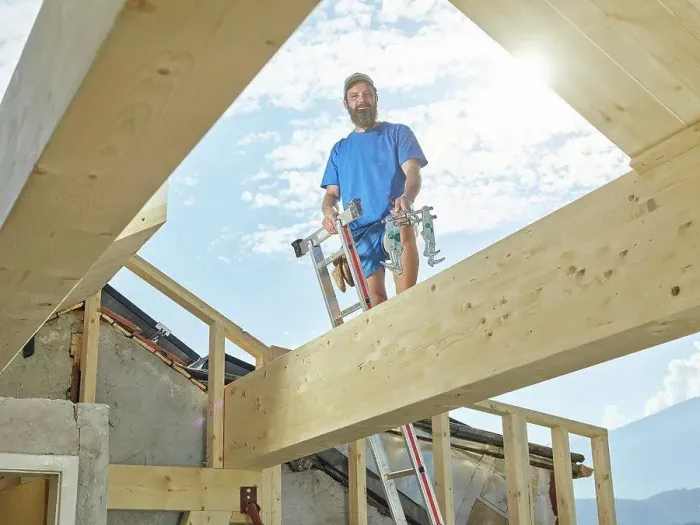 Framed Print : Young man standing on ladder at construction site