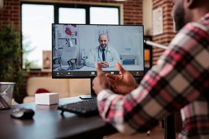 Framed Print : Young man talking to doctor on videocall Framed Print : Young man talking to doctor on videocall
