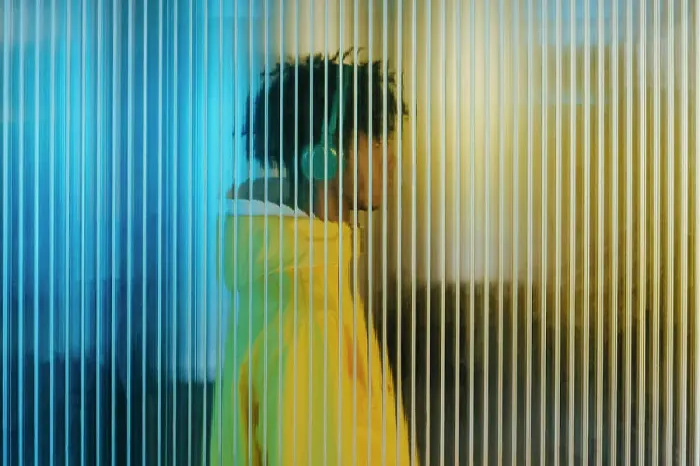 Framed Print : Young man in wireless headphones behind futuristic wall Framed Print : Young man in wireless headphones behind futuristic wall