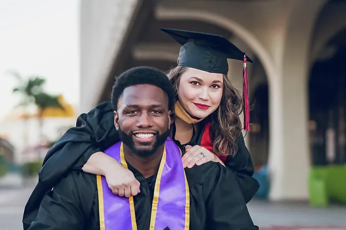 Framed Print : Young man & woman graduating college, wearing a graduation gown / cap Framed Print : Young man & woman graduating college, wearing a graduation gown / cap