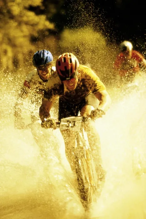 Framed Print : Young men riding bicycles through water Framed Print : Young men riding bicycles through water