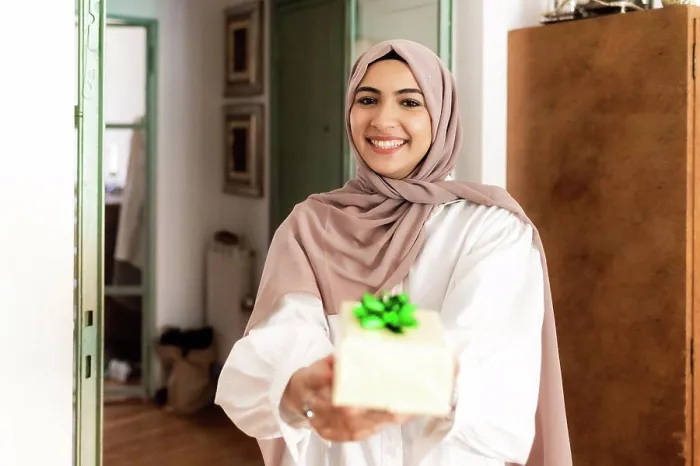 Framed Print : Young muslim woman giving a gift Framed Print : Young muslim woman giving a gift