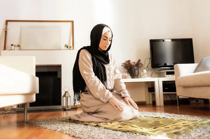 Framed Print : Young muslim woman kneeling on mat for prayer Framed Print : Young muslim woman kneeling on mat for prayer