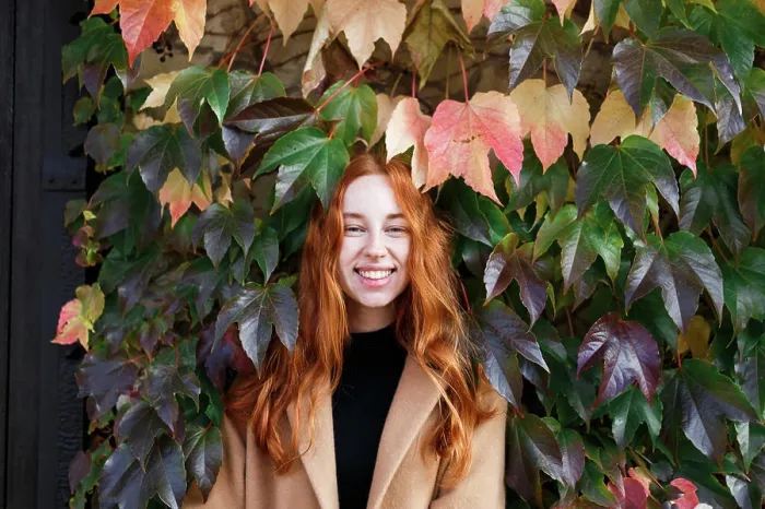 Framed Print : young stylish red-haired woman on the background of green leaves Framed Print : young stylish red-haired woman on the background of green leaves