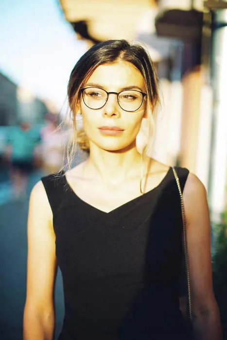 Framed Print : Young woman in black dress and glasses in the sunny city Framed Print : Young woman in black dress and glasses in the sunny city