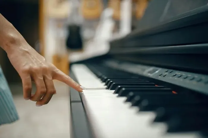 Framed Print : Young woman choosing digital piano in music store