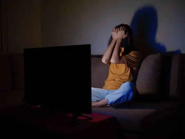 Framed Print : Young woman covering face with palms watching tv at night time Framed Print : Young woman covering face with palms watching tv at night time