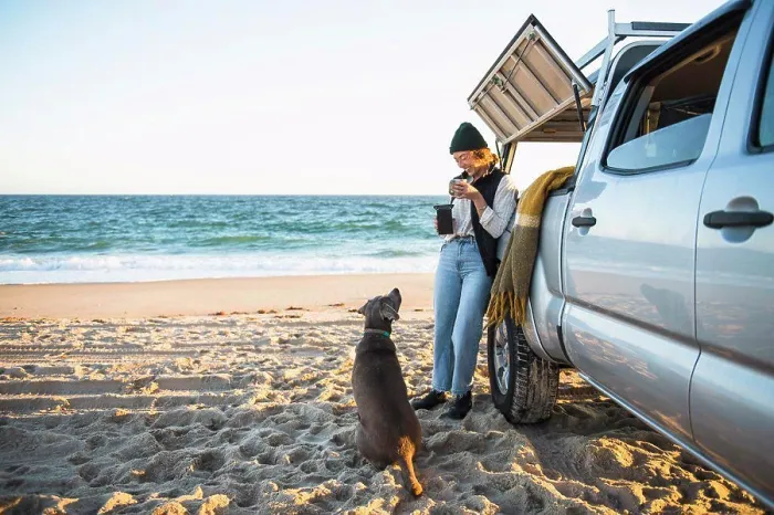 Framed Print : Young woman and her dog while beach car camping alone
