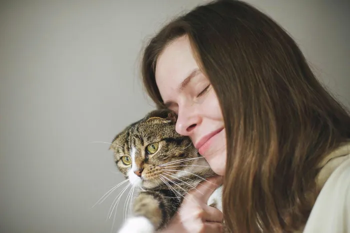 Framed Print : Young woman holding beautiful cat on white background