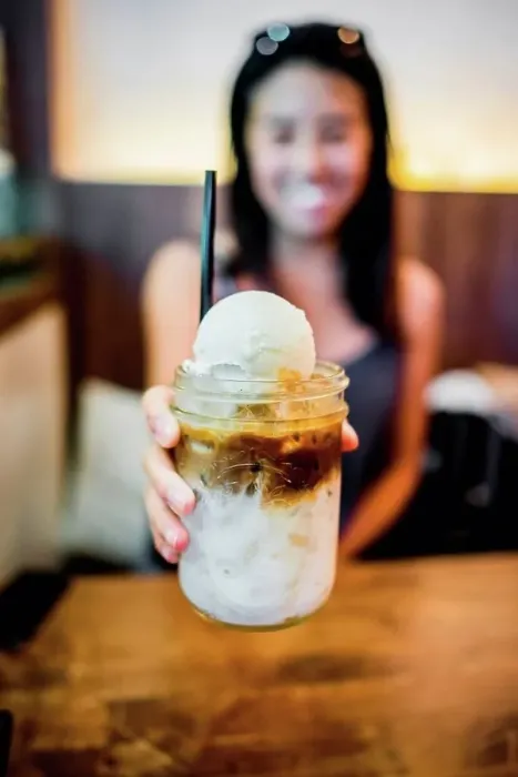 Framed Print : Young woman holding coffee float at Farm to Table, Bangkok, Thailand Framed Print : Young woman holding coffee float at Farm to Table, Bangkok, Thailand