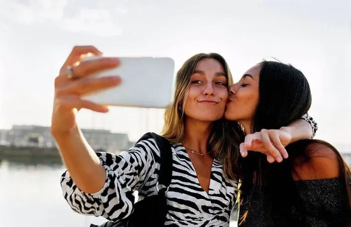 Framed Print : Young woman kissing friend while taking selfie against clear sky Framed Print : Young woman kissing friend while taking selfie against clear sky