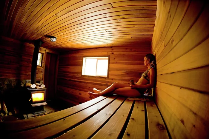 Framed Print : A young woman recouping after skiing in the sauna at Sol Mountain Lodge, British Columbia
