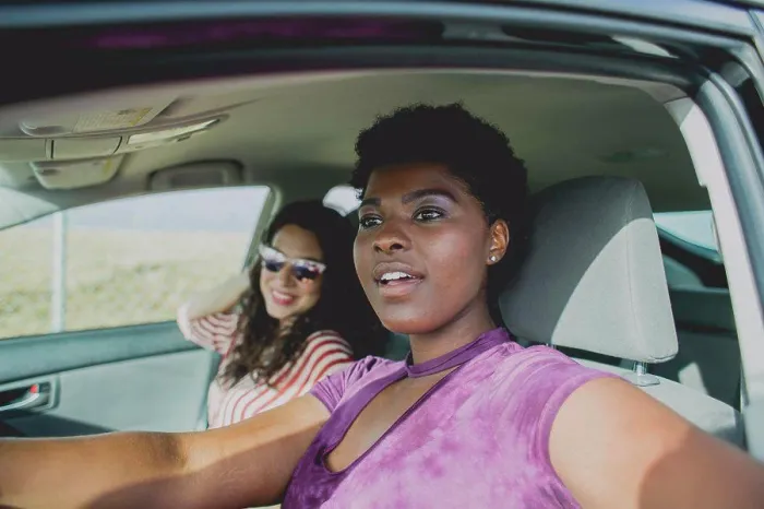 Framed Print : Young woman sitting with female friend looking away while sitting in car on sunny day Framed Print : Young woman sitting with female friend looking away while sitting in car on sunny day