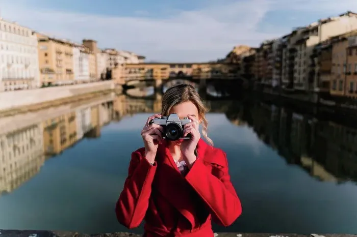 Framed Print : Young woman taking a picture on a bridge above river Arno, Florence, Italy Framed Print : Young woman taking a picture on a bridge above river Arno, Florence, Italy
