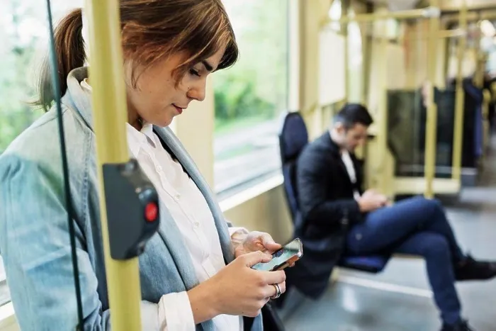 Framed Print : Young woman using mobile phone in tram Framed Print : Young woman using mobile phone in tram