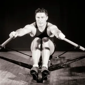 1930s MAN MUSCULAR ATHLETE CONCENTRATED FOCUSED FACIAL EXPRESSION EXERCISING WORKING OUT ON GYMNASIUM STATIONARY ROWING 1930s MAN MUSCULAR ATHLETE CONCENTRATED FOCUSED FACIAL EXPRESSION EXERCISING WORKING OUT ON GYMNASIUM STATIONARY ROWING