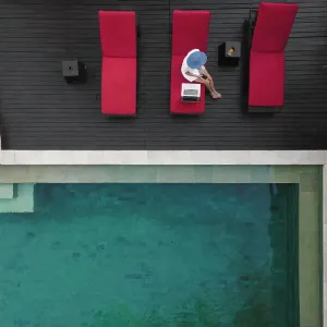 Aerial view young woman with laptop near pool Aerial view young woman with laptop near pool