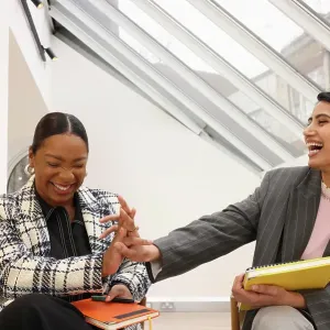 Businesswomen laughing in office Businesswomen laughing in office