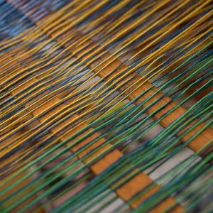 Close up green and yellow thread on loom Close up green and yellow thread on loom