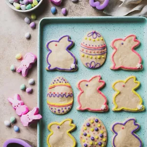 Easter cookies shaped like eggs and bunnies on green tray from above Easter cookies shaped like eggs and bunnies on green tray from above