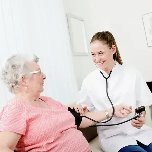 Elderly senior woman with young doctor having medical care at home Elderly senior woman with young doctor having medical care at home