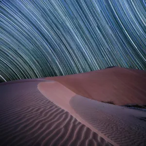 Equatorial star trail above sand dunes in the Rub al Khali desert, Oman, Middle East Equatorial star trail above sand dunes in the Rub al Khali desert, Oman, Middle East