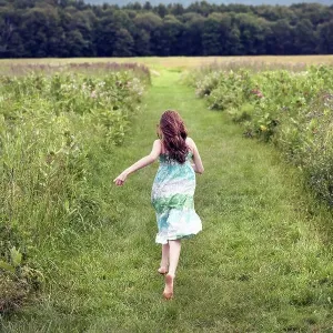 A girl running through a meadow in summer