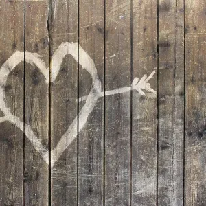 Heart shape with arrow symbol on wooden fence Heart shape with arrow symbol on wooden fence