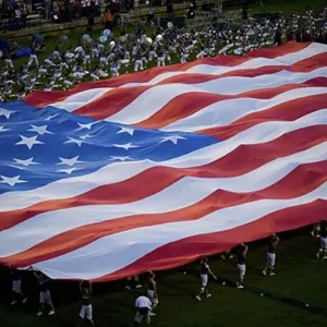 High angle view of a group of people holding a large American Flag
