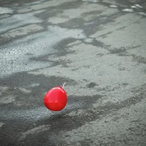 Red ball flies over asphalt. Balloon outside Red ball flies over asphalt. Balloon outside