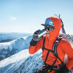 Ski mountaineer taking a break and drinking a hot beverage Ski mountaineer taking a break and drinking a hot beverage