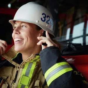 Smiling female firefighter wearing helmet at fire station Smiling female firefighter wearing helmet at fire station