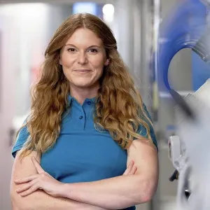 Smiling technician standing with arms crossed in factory Smiling technician standing with arms crossed in factory