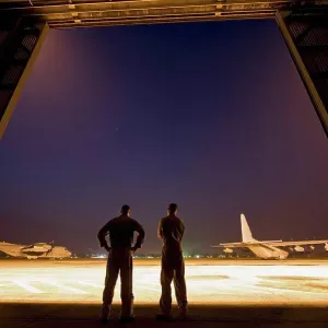 Two United States Marine aviators scan the flight line on which two KC-130J Super Hercules sit parked at Kuantan Air Two United States Marine aviators scan the flight line on which two KC-130J Super Hercules sit parked at Kuantan Air