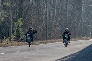Thrill Prints: 15 year old boys in helmets ride their motorcycles on a rural road