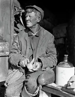 Weathered Prints: 1920S 1930S Elderly Man Weathered Face Sitting Beside Jug Carving Duck Decoy