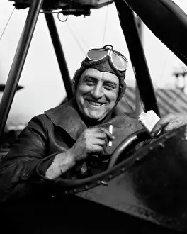 Smoking Prints: 1920S 1930S Pilot Smiling Man In Cockpit Of Airplane Taking Cigarette Out Of Pack