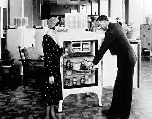 Retail Prints: 1920S 1930S Salesman Demonstrating Refrigerator To Woman Shopper